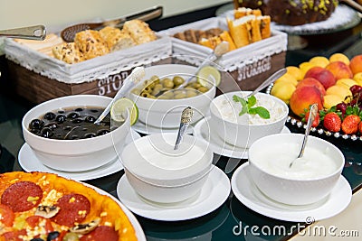 A selection of sauces, olives, curd and garnishes at the buffet counter of a restaurant Stock Photo