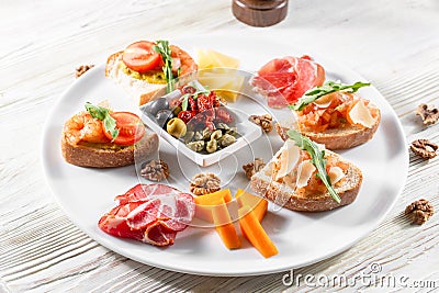 Selection of tasty bruschetta or canapes on taosted baguette and quark cheese topped with smoked salmon, shrimp. Stock Photo