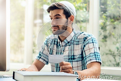 Selectiv focused of health insurance card holding in hands of muslim businessman wearing kufi hat working at home Stock Photo