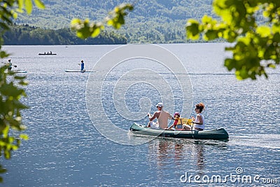 Selective blur on a family, father, mother, daughter, paddling on a canoe, canoeing, on lake Bohinj, a major tourist destination Editorial Stock Photo