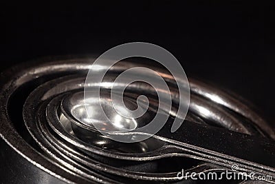 Selective blur on a macro shot of Stainless steel metal measuring spoons, teaspoons, of various quantities, used for cooking, like Stock Photo