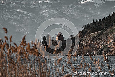 Selective of a church on a rock near the lake from the reeds Stock Photo