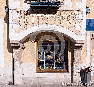 Selective focus on an ancient wall with a window decorated with traditional pretzels. Autumn morning in a small town Stock Photo