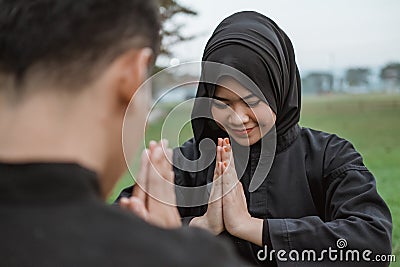 Selective focus of Asian women wearing hijabs wearing pencak silat uniforms with poses of respect for their opponents Stock Photo
