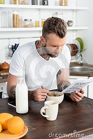 Focus of bearded, tattooed man reading Stock Photo