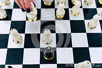 Selective focus of beautiful chess on chessboard. Close up of body part of unrecognizable woman playing in board game on Stock Photo