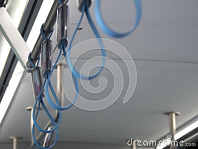 Selective focus of blue loop handles inside metro subway train for the safety of standing passenger while using transportation in Stock Photo