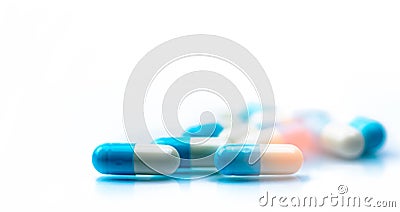 Selective focus on blue and white capsules pill spread on white background with shadow. Global healthcare concept. Antibiotics Stock Photo