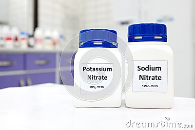 Selective focus of bottles of sodium nitrate and potassium nitrate chemical preservative. White laboratory background. Stock Photo