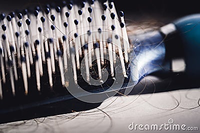 Selective focus on bristles of a hairbrush with tangled hair Stock Photo