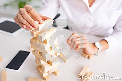 Selective focus of businesswoman playing blocks Stock Photo