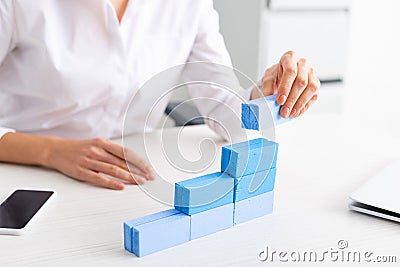 Selective focus of businesswoman stacking blue Stock Photo