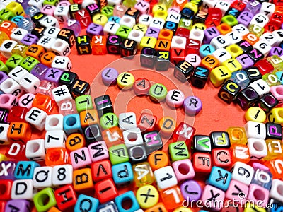 Selective focus.Colorful dice with word LEADER on red background.Shot were noise and film grain. Stock Photo