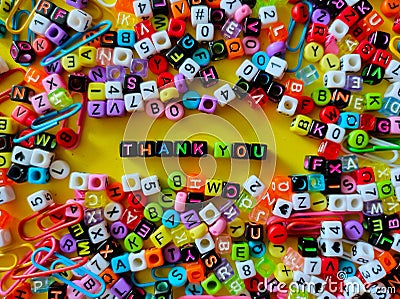 Selective focus.Colorful dice with word THANK YOU on yellow background.Shot were noise and film grain. Stock Photo