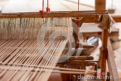 Selective focus of cotton thread on weaver machine. Thai cotton handmade. Homespun fabric process. The process of fabric weaving Stock Photo