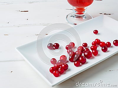 Selective focus on cranberries on a white rectangular ceramic plate Stock Photo