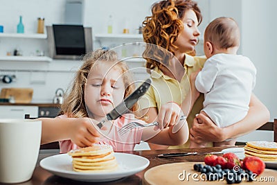 Focus of displeased girl holding fork Stock Photo