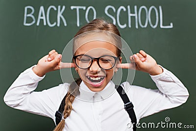 Selective focus of displeased schoolgirl in Stock Photo