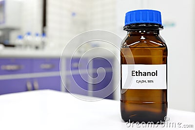 Selective focus of ethanol or ethyl alcohol in brown glass bottle inside a laboratory. Stock Photo