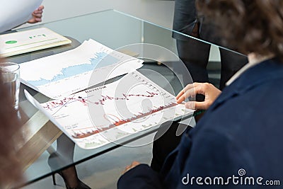 selective focus on a finance graph and unrecognizable people out of focus Stock Photo