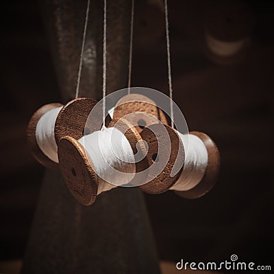 Vintage wooden spools of white threads closeup. Thread shabby bobbins with white cotton yarn. Stock Photo