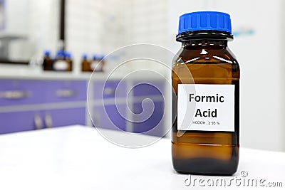 Selective focus of Formic acid solution in brown amber bottle. Blur white laboratory backdrop with copy space. Stock Photo