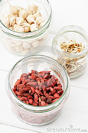 Selective focus of goji berries and sprouts in glass jars Stock Photo