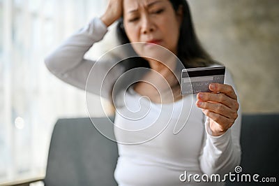 selective focus image, Stressed Asian mature woman having financial problems Stock Photo