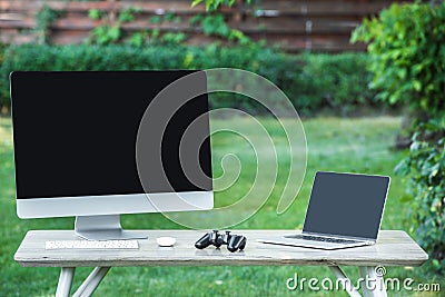 selective focus of joystick computer and laptop with blank screens on table Stock Photo