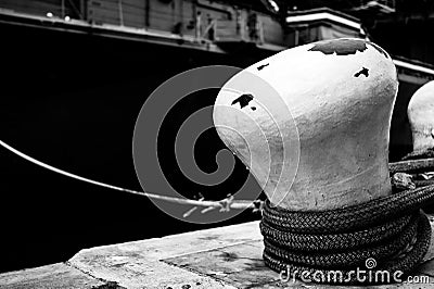 Selective focus on line securing a naval boat to a port bollard. Stock Photo