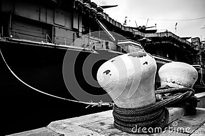 Selective focus on line securing a naval boat to a port bollard. Stock Photo