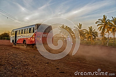 Selective focus Local Bus driving fast with dust cloud on road to Bidar Editorial Stock Photo