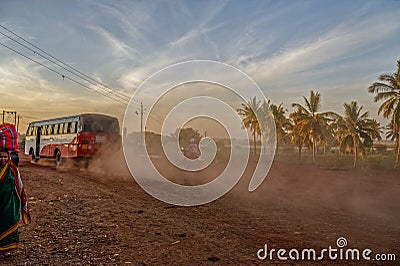 Selective focus Local Bus driving fast with dust cloud on road to Bidar Editorial Stock Photo