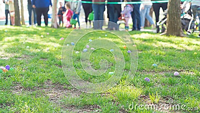 Selective focus long line of diverse kids with parents after brightly colored barricade tape and multicolor Easter eggs Stock Photo