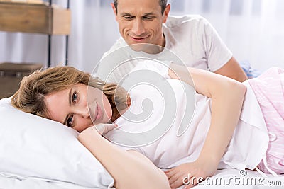 selective focus of man looking at smiling wife lying near Stock Photo