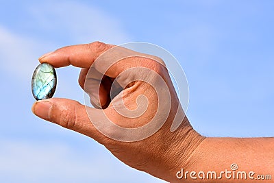 Selective focus of a man's hand holding a cracked semi-precious stone on a blurred background Stock Photo