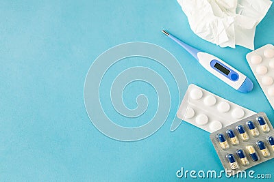 Selective focus on medical pills, used tissue and thermometer on blue background, copy space Stock Photo