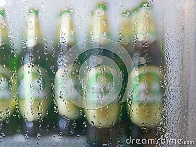 Selective focus of moisture on the outside of a refrigerator door with bottles of cold drink inside Stock Photo