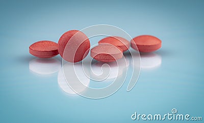 Selective focus on orange round tablets with shadow on gradient background. Pharmaceutical industry. Pharmacy products. Vitamins Stock Photo