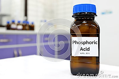 Selective focus of Phosphoric acid solution in brown amber bottle. Blur white laboratory backdrop with copy space. Stock Photo