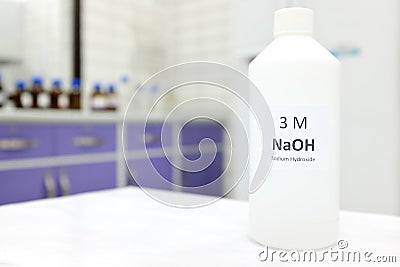 Selective focus of a plastic bottle of sodium hydroxide solution or NaOH chemical reagent. Chemistry research laboratory. Stock Photo