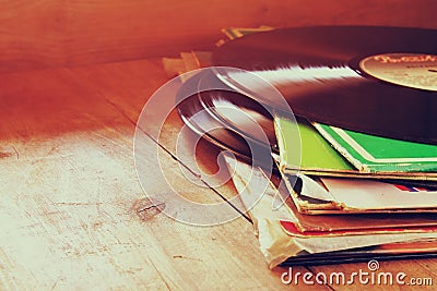 Selective focus of records stack with record on top over wooden table. vintage filtered Stock Photo