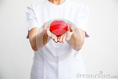 Selective focus of red heart held by female nurse`s both hand, representing giving all effort to deliver high quality service mind Stock Photo