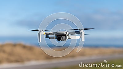 Selective focus shot of a flying drone - Mavic Mini, in the air near the beach on Kiel, Germany Editorial Stock Photo