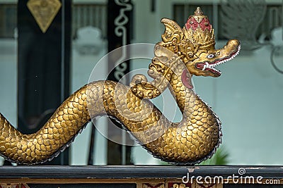 Selective focus shot of a golden snake statue with a blurred background Stock Photo
