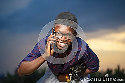 Selective focus shot of a handsome smiling African-American male talking on the phone Editorial Stock Photo