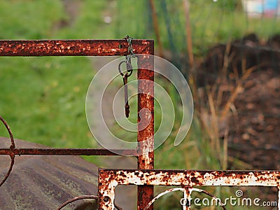 Selective focus shot of a hanging rusty key with a blurred background Stock Photo