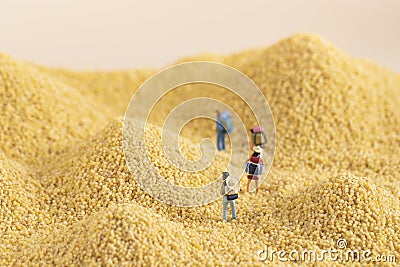 Selective focus shot of miniature backpackers on a pile of grain - hiking concept Stock Photo