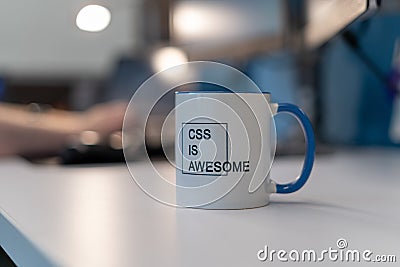 Selective focus shot of a mug with a printed text of CSS IS AWESOME with a blurred background Editorial Stock Photo