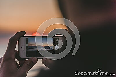 Selective focus shot of a person taking a picture with a smartphone Editorial Stock Photo